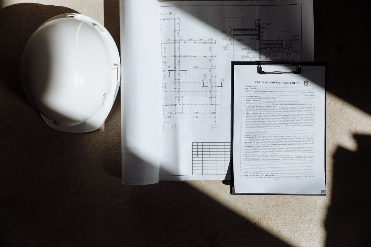 Drawings and project documents beside a hard hat